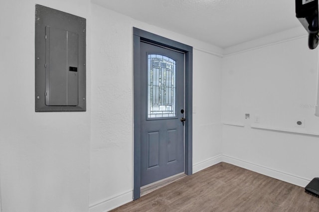 foyer featuring electric panel, hardwood / wood-style floors, and a textured ceiling