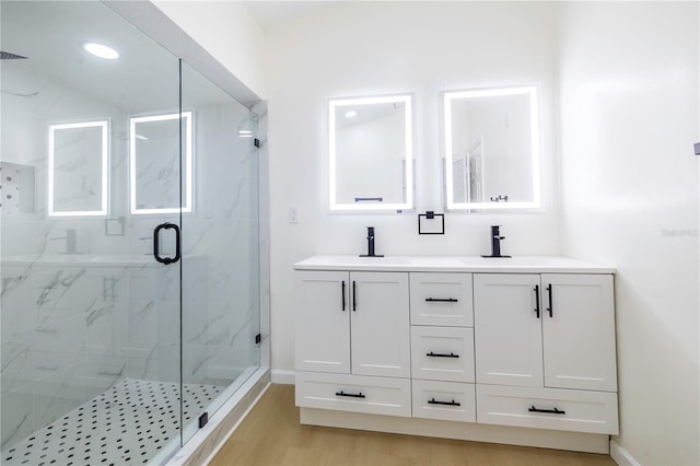 bathroom featuring vanity, hardwood / wood-style flooring, and a shower with shower door