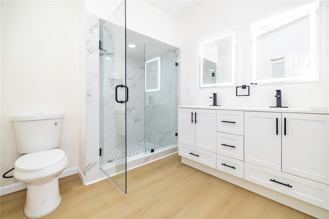 bathroom with vanity, hardwood / wood-style flooring, toilet, and a shower with door