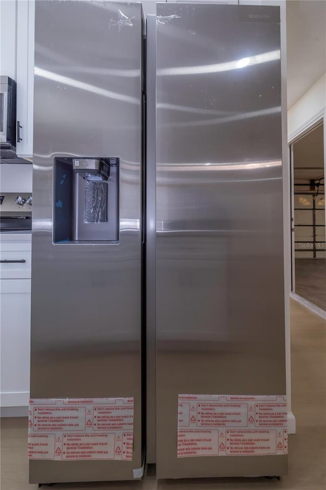 details with hardwood / wood-style floors and stainless steel appliances