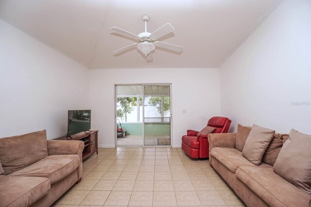 living room with lofted ceiling, ceiling fan, and light tile patterned floors