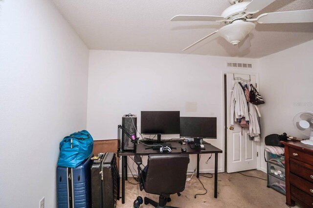 carpeted office space featuring ceiling fan