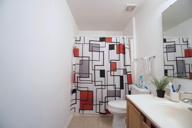 bathroom with vanity, curtained shower, tile patterned floors, and toilet