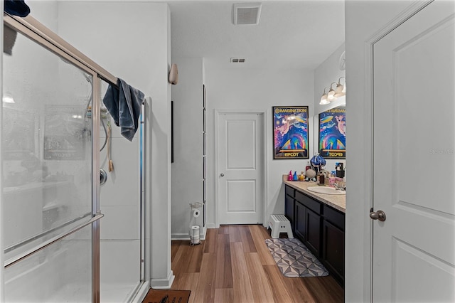 bathroom with vanity, hardwood / wood-style floors, and a shower with shower door