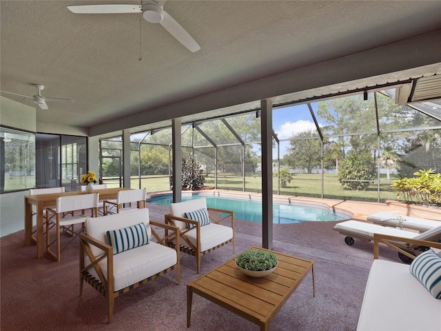 sunroom featuring ceiling fan and a pool