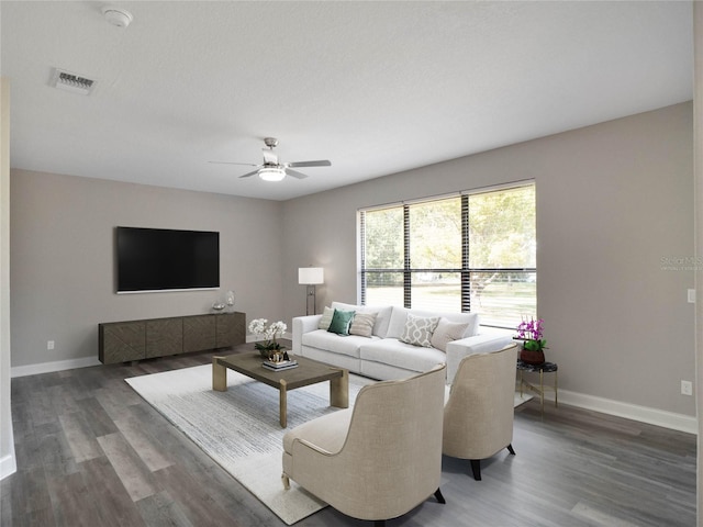 living room with ceiling fan, a textured ceiling, and dark hardwood / wood-style flooring