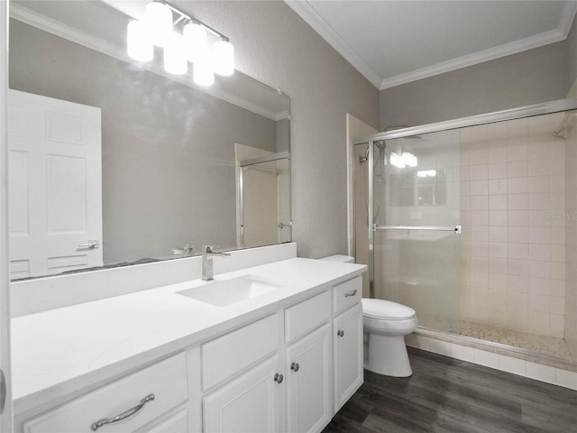 bathroom featuring hardwood / wood-style flooring, vanity, crown molding, a shower with shower door, and toilet