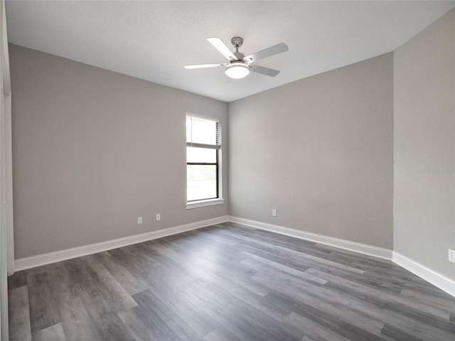 spare room featuring dark wood-type flooring and ceiling fan