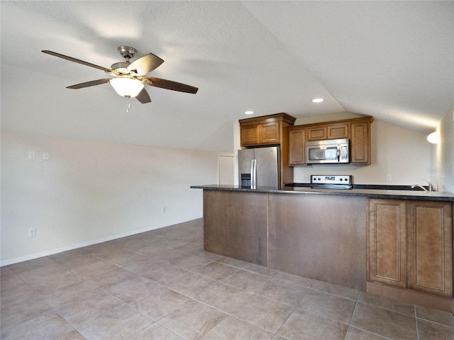 kitchen with stainless steel appliances, dark stone counters, vaulted ceiling, kitchen peninsula, and ceiling fan