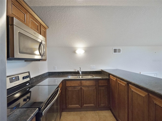 kitchen featuring light tile patterned floors, a textured ceiling, sink, and appliances with stainless steel finishes