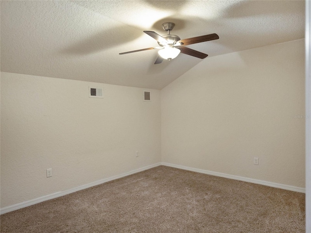 unfurnished room with a textured ceiling, carpet, lofted ceiling, and ceiling fan