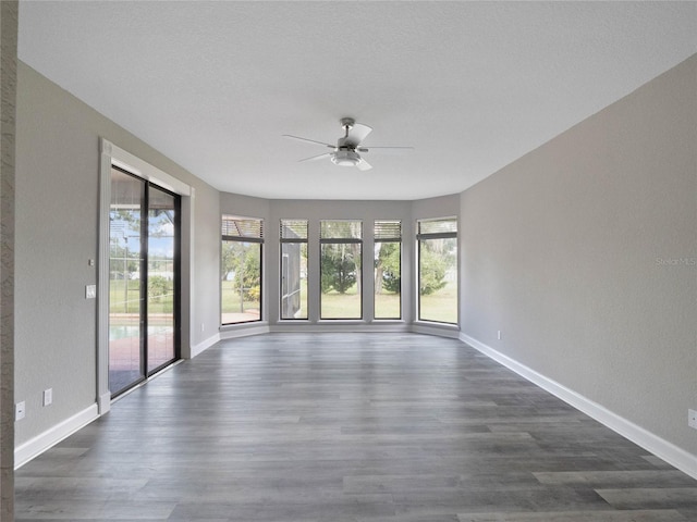 spare room featuring a textured ceiling, dark wood-type flooring, and ceiling fan