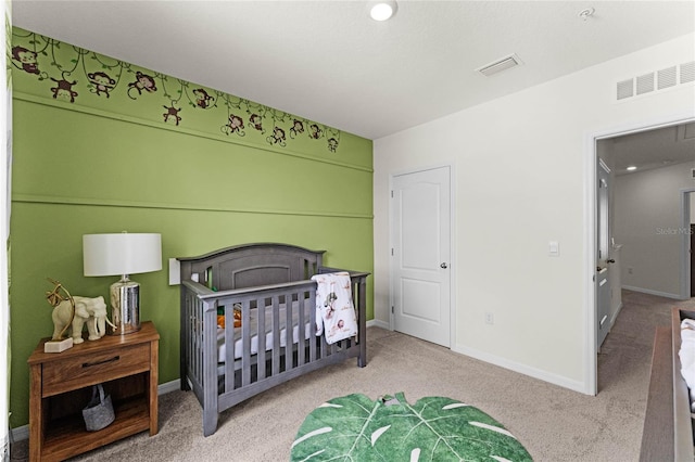 bedroom featuring light carpet and a crib