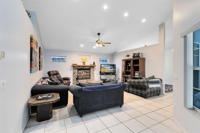 living room featuring ceiling fan, light tile patterned flooring, and a fireplace