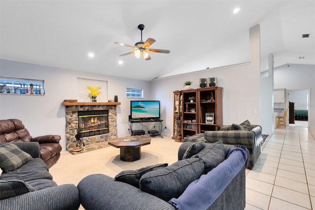 tiled living room featuring a stone fireplace, high vaulted ceiling, and ceiling fan