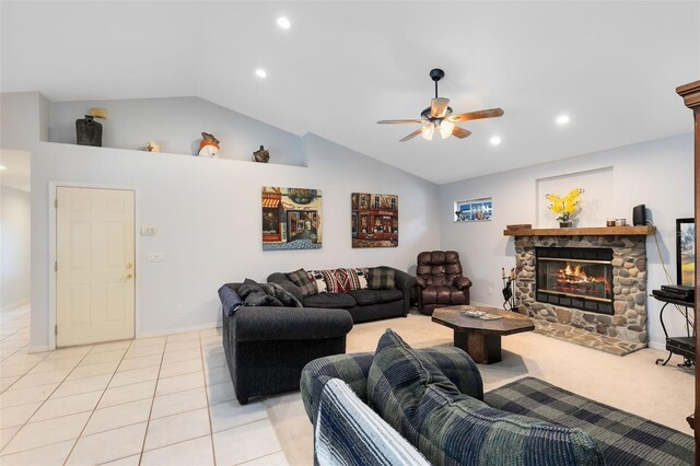 tiled living room featuring vaulted ceiling, ceiling fan, and a fireplace