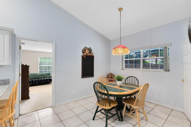 tiled dining area with lofted ceiling