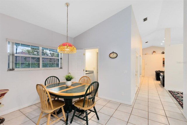 dining space featuring lofted ceiling and light tile patterned floors
