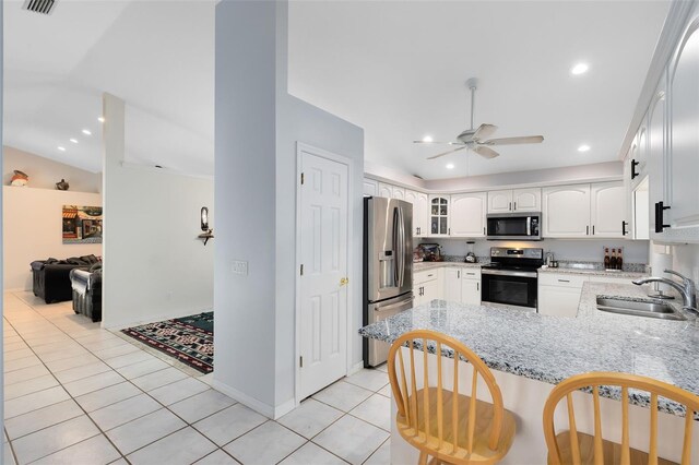 kitchen with stainless steel appliances, sink, kitchen peninsula, light tile patterned floors, and white cabinets