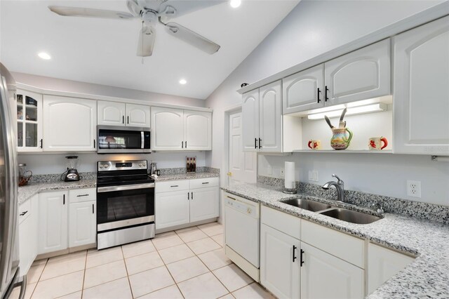 kitchen featuring white cabinetry, sink, appliances with stainless steel finishes, light tile patterned floors, and lofted ceiling