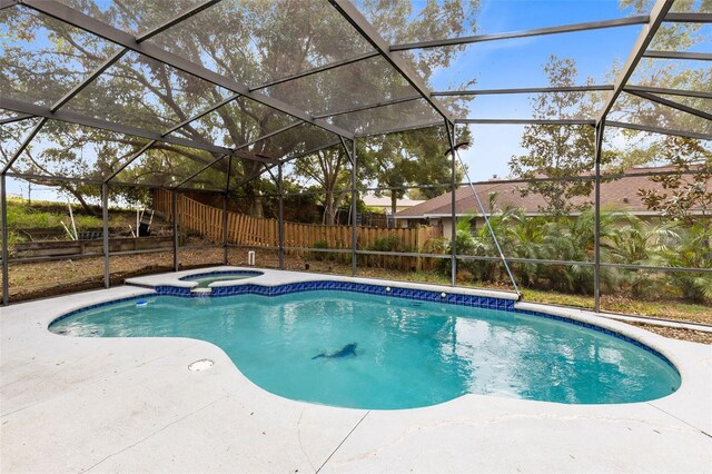 view of swimming pool with a patio area, glass enclosure, and an in ground hot tub