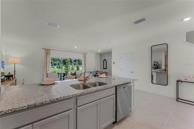 kitchen featuring sink, dishwasher, light stone countertops, and light tile patterned flooring