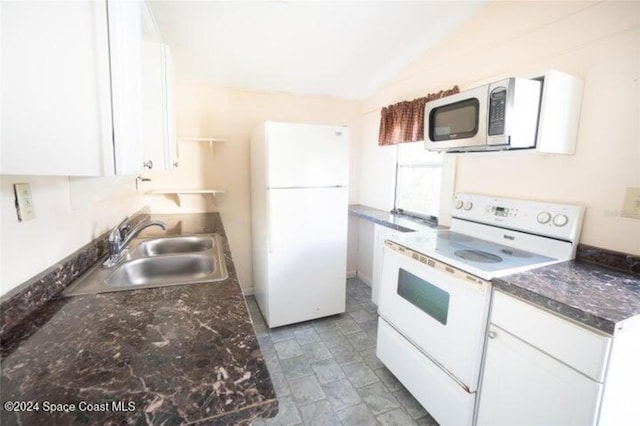 kitchen featuring white appliances, lofted ceiling, sink, and white cabinets