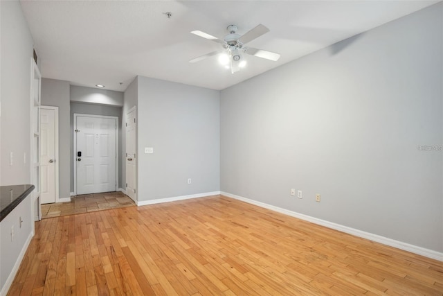 empty room with ceiling fan and light wood-type flooring