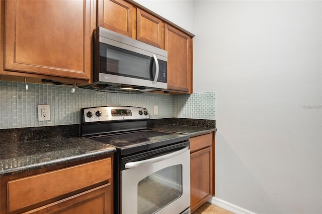 kitchen with decorative backsplash, stainless steel appliances, and dark stone counters