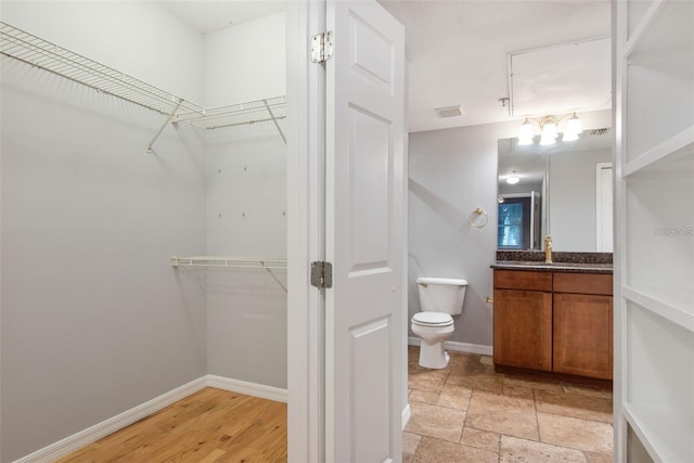 bathroom featuring toilet, hardwood / wood-style floors, and vanity