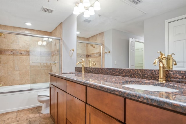 full bathroom featuring toilet, combined bath / shower with glass door, and vanity