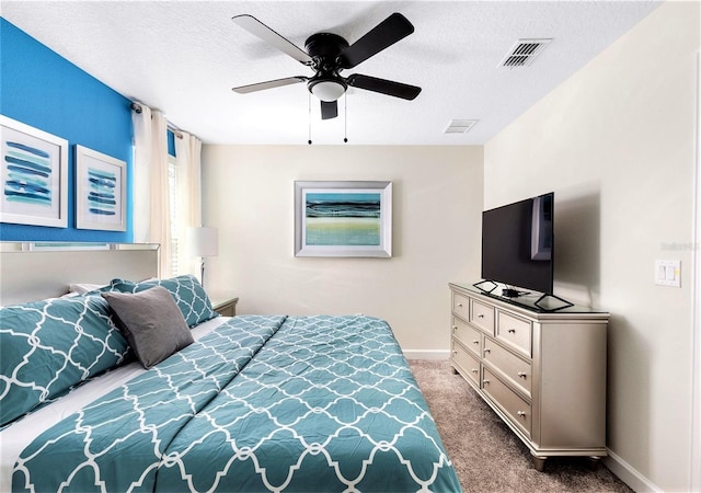 bedroom featuring carpet flooring, a textured ceiling, and ceiling fan