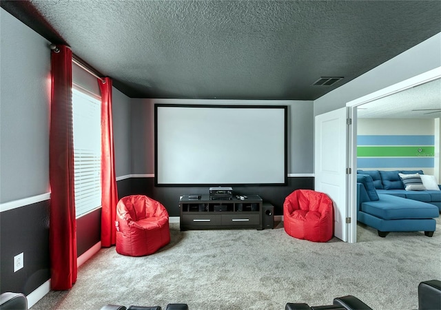 carpeted home theater room featuring a textured ceiling