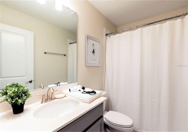 bathroom featuring vanity, a textured ceiling, and toilet