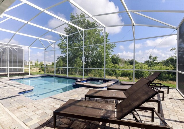 view of swimming pool with a patio, a lanai, and an in ground hot tub