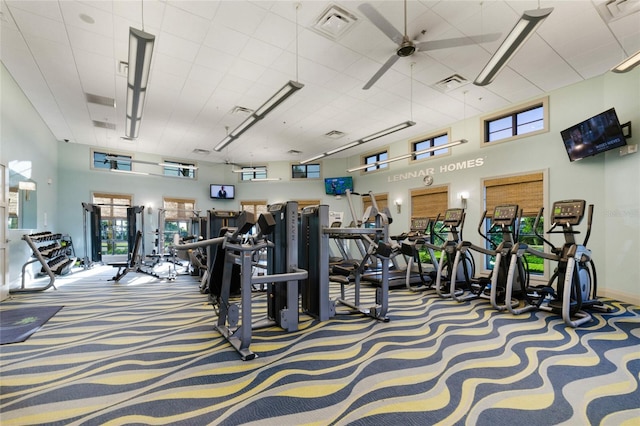 workout area with carpet flooring, ceiling fan, and a towering ceiling