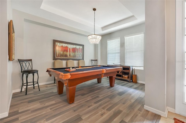 game room with dark hardwood / wood-style floors, a chandelier, billiards, and a tray ceiling