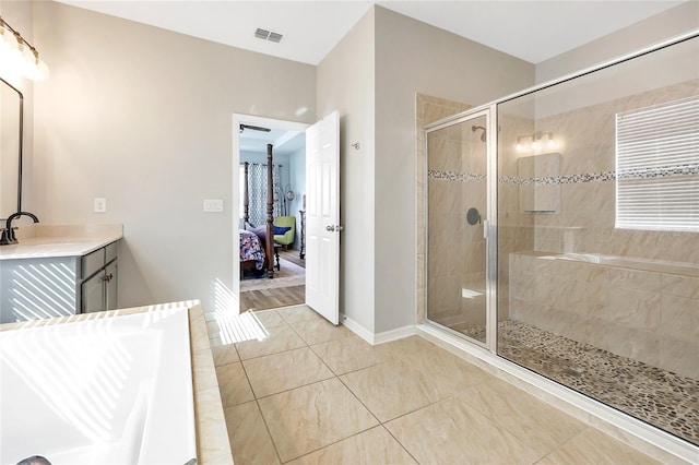 bathroom with vanity and shower with separate bathtub