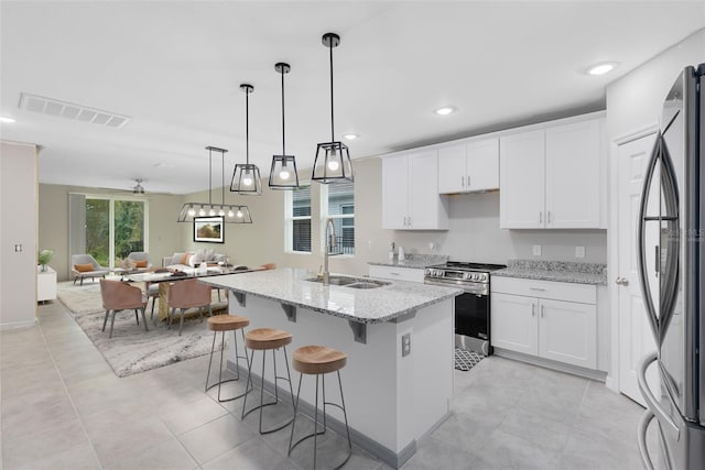 kitchen with light stone countertops, white cabinetry, sink, and appliances with stainless steel finishes