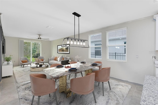 dining space featuring ceiling fan and light tile patterned floors