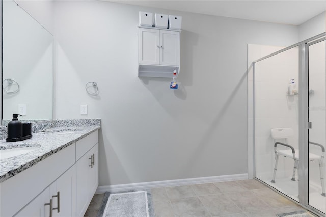 bathroom featuring tile patterned floors, vanity, and a shower with door