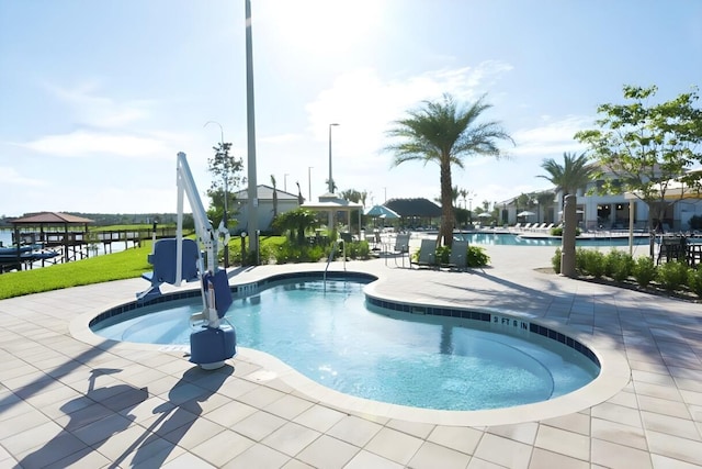 view of swimming pool with a water view and a patio area