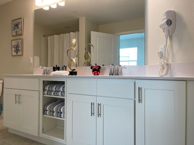 bathroom featuring vanity, tile patterned floors, and a textured ceiling