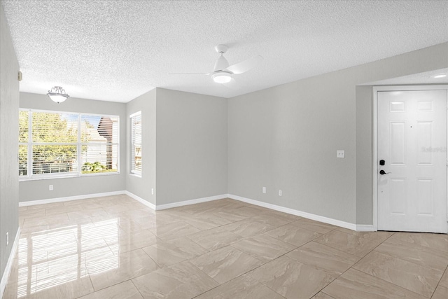 spare room featuring ceiling fan and a textured ceiling