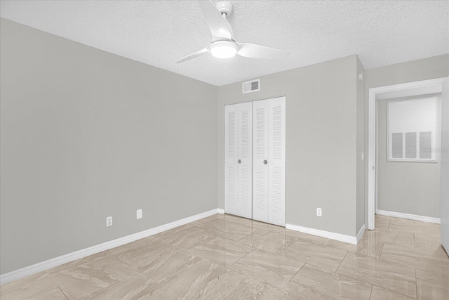 unfurnished bedroom with a closet, ceiling fan, and a textured ceiling