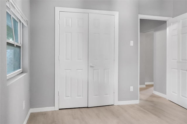 unfurnished bedroom featuring light wood-type flooring and a closet