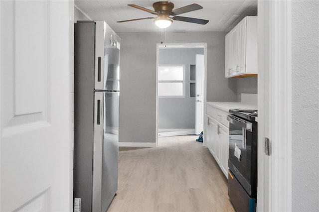 kitchen with black electric range oven, white cabinets, ceiling fan, stainless steel fridge, and light wood-type flooring