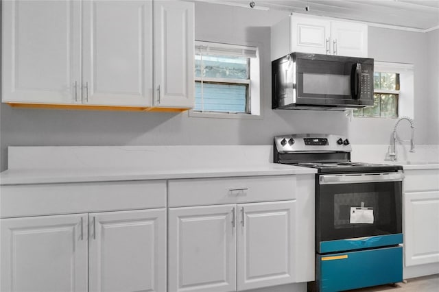 kitchen featuring white cabinetry, stainless steel electric range oven, and sink