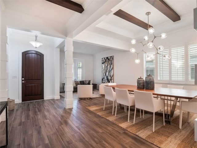 dining area featuring dark hardwood / wood-style floors, crown molding, decorative columns, and an inviting chandelier