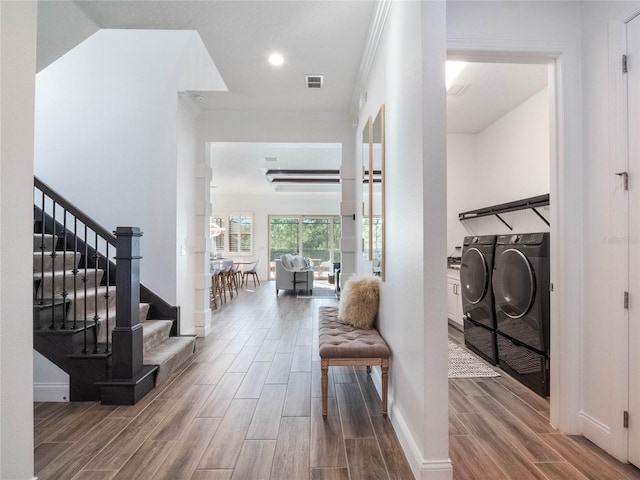 foyer featuring hardwood / wood-style flooring, ornamental molding, and washer and clothes dryer